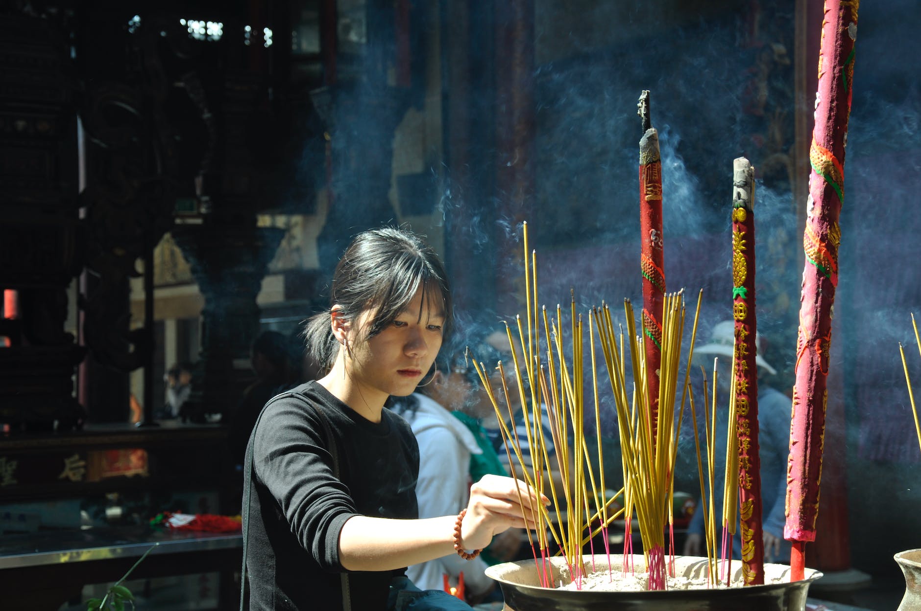 woman lighting incense sticks