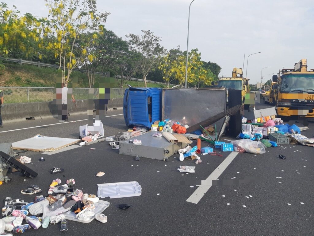 小貨車國道爆胎翻覆，物品散落一地，女駕駛受困